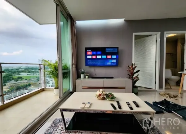 Condominium for rent in Huai Khwang, Bangkok - Corner living room opening to large balcony with pool and skyline views at TC Green Rama 9.