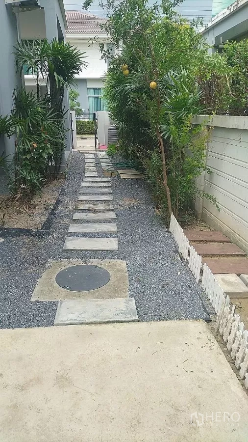 บ้าน ขายในLat Krabang, Bangkok - ทางเดินสวนข้างบ้าน โรยหินกรวดและแผ่นปูทาง มีต้นไม้และพุ่มไม้ตลอดแนว