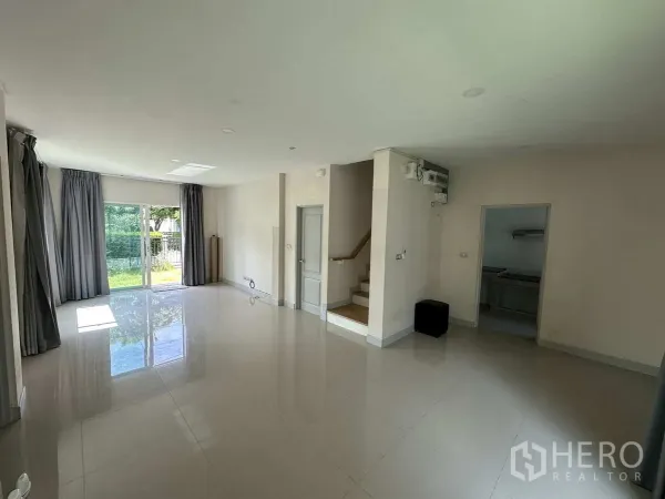 บ้าน ให้เช่าในKhlong Luang, Pathum Thani - ห้องนั่งเล่นโปร่ง พื้นกระเบื้องเงา พร้อมบันไดขึ้นชั้นสอง