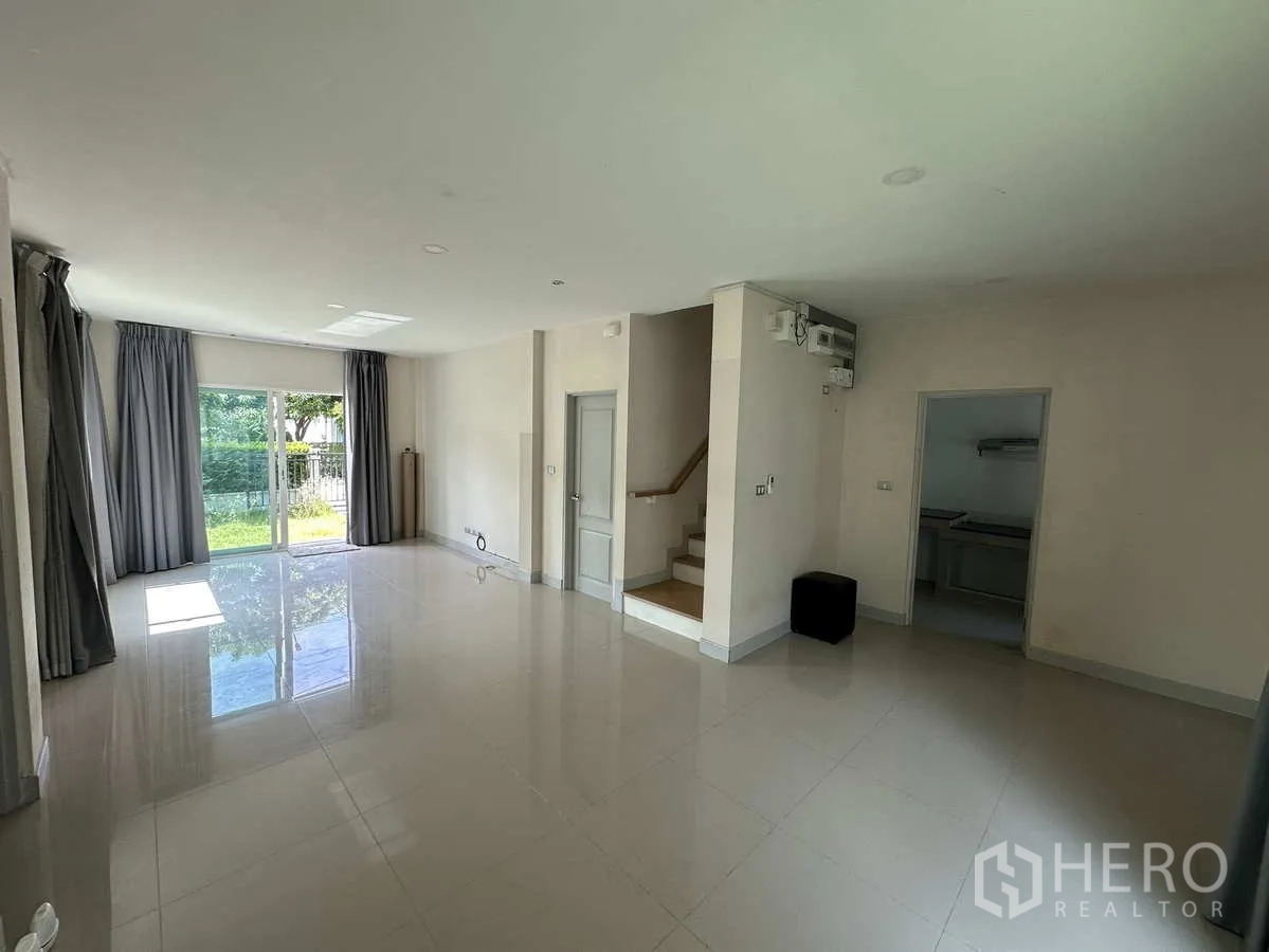 บ้าน ให้เช่าในKhlong Luang, Pathum Thani - ห้องนั่งเล่นโปร่ง พื้นกระเบื้องเงา พร้อมบันไดขึ้นชั้นสอง