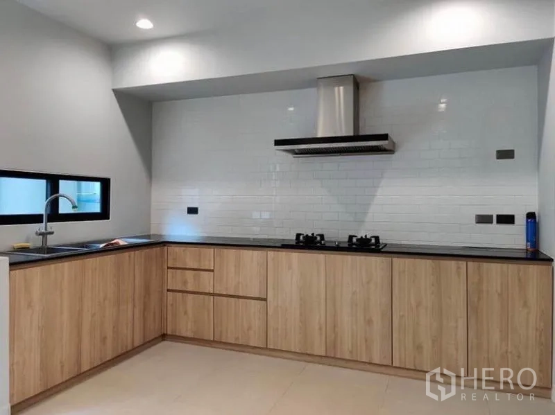 ทาวน์เฮาส์ ให้เช่าในSuan Luang, Bangkok - ครัวยูรูปตัวแอล ตู้ไม้ เตาแก๊ส และเครื่องดูดควันสแตนเลส