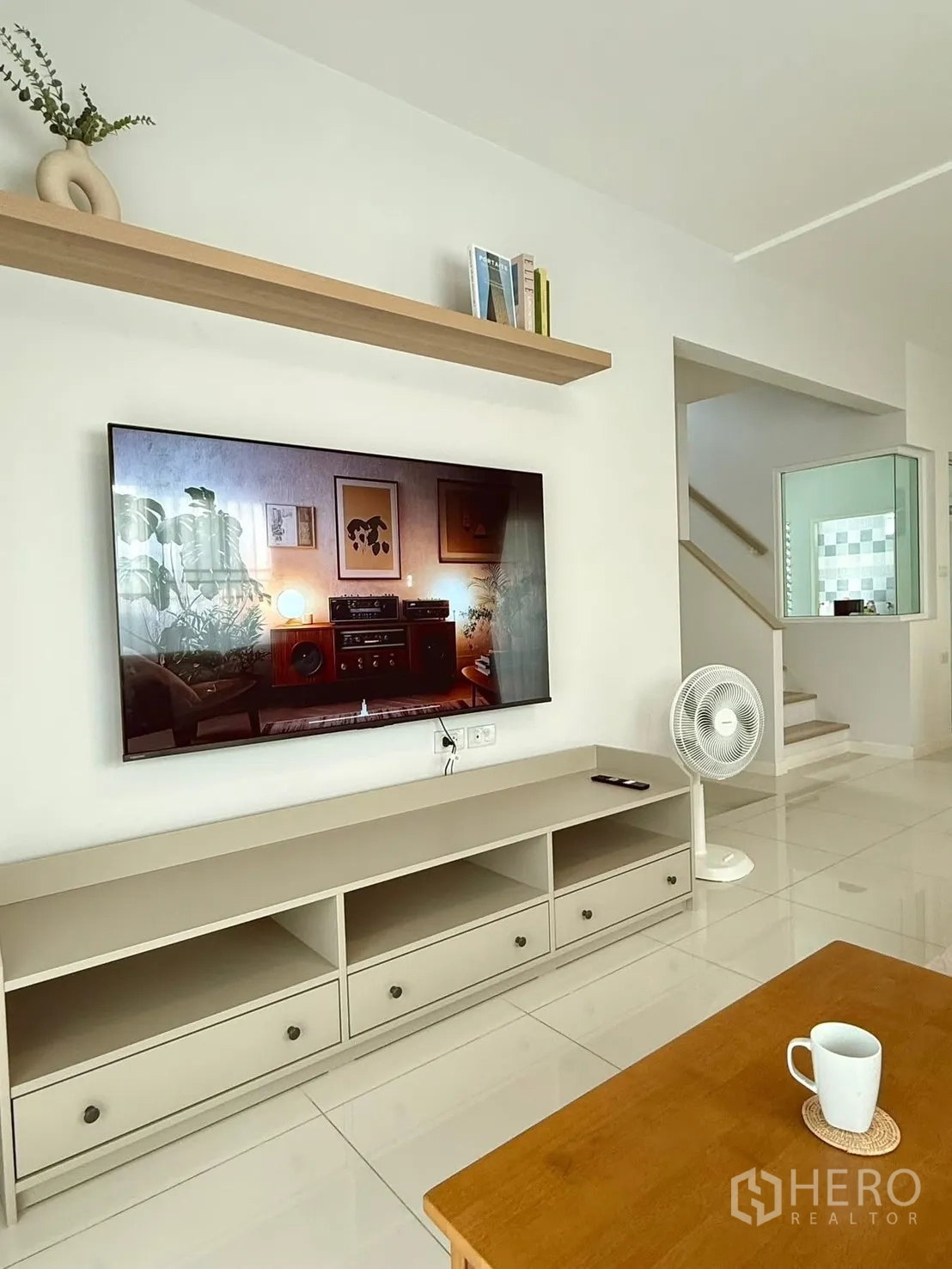 独栋房屋 for rent in Bang Phli, Samut Prakan - 电视背景墙带置物层板与矮柜，旁有楼梯。