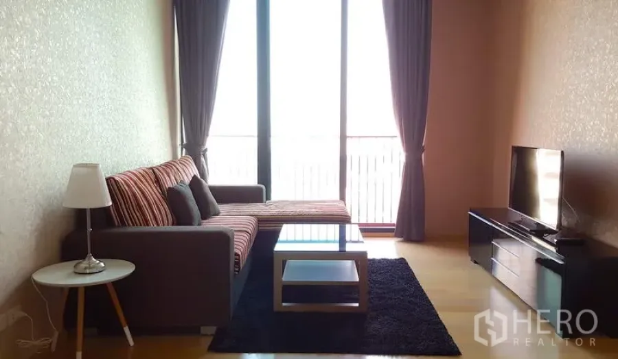 คอนโด ให้เช่าในPhaya Thai, Bangkok - ห้องนั่งเล่น โซฟาเข้ามุม โต๊ะกลางกระจก ชั้นวางทีวี และหน้าต่างสูงจรดเพดาน