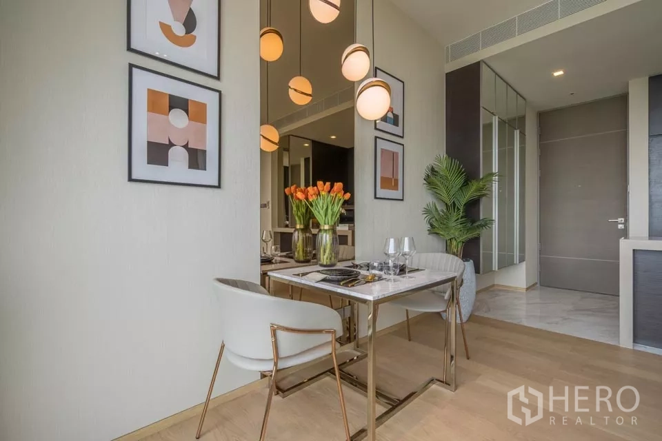 公寓 出租或出售在Bang Rak, Bangkok - 餐区配大理石餐桌、吊灯与现代装饰画。