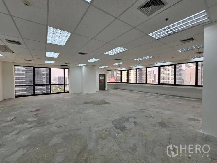 办公空间 出租在Bang Rak, Bangkok - 大型开放式办公室，网格天花与转角窗，俯瞰曼谷天际线。