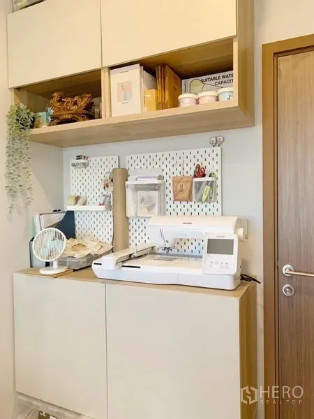 Condominium for sale in Suan Luang, Bangkok - Compact home office corner with wall shelves, pegboard organizer and storage cabinet.