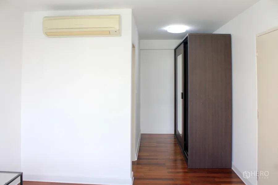 คอนโด ให้เช่าหรือขายในWatthana, Bangkok - โถงทางเดินสว่าง พื้นไม้ แอร์แขวนผนัง และตู้เสื้อผ้าบานกระจกสีเข้ม