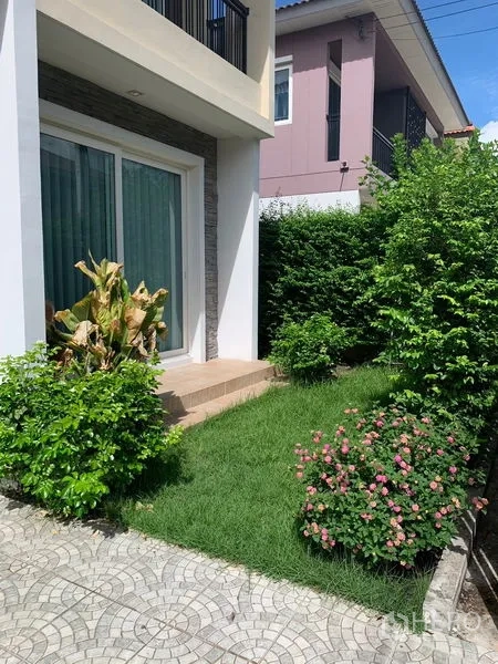 Detached House for sale in Prawet, Bangkok - Landscaped front garden with lawn, shrubs and sliding glass doors.