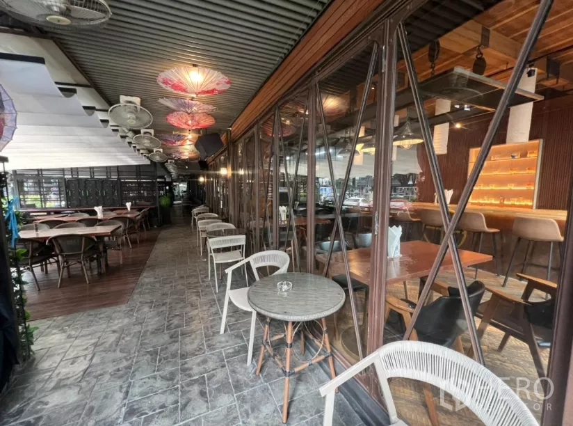 พื้นที่ขายปลีก ให้เช่าในWatthana, Bangkok - ระเบียงข้างอาคารมีโต๊ะบิสโตรติดผนังกระจกมองเห็นบาร์ด้านใน