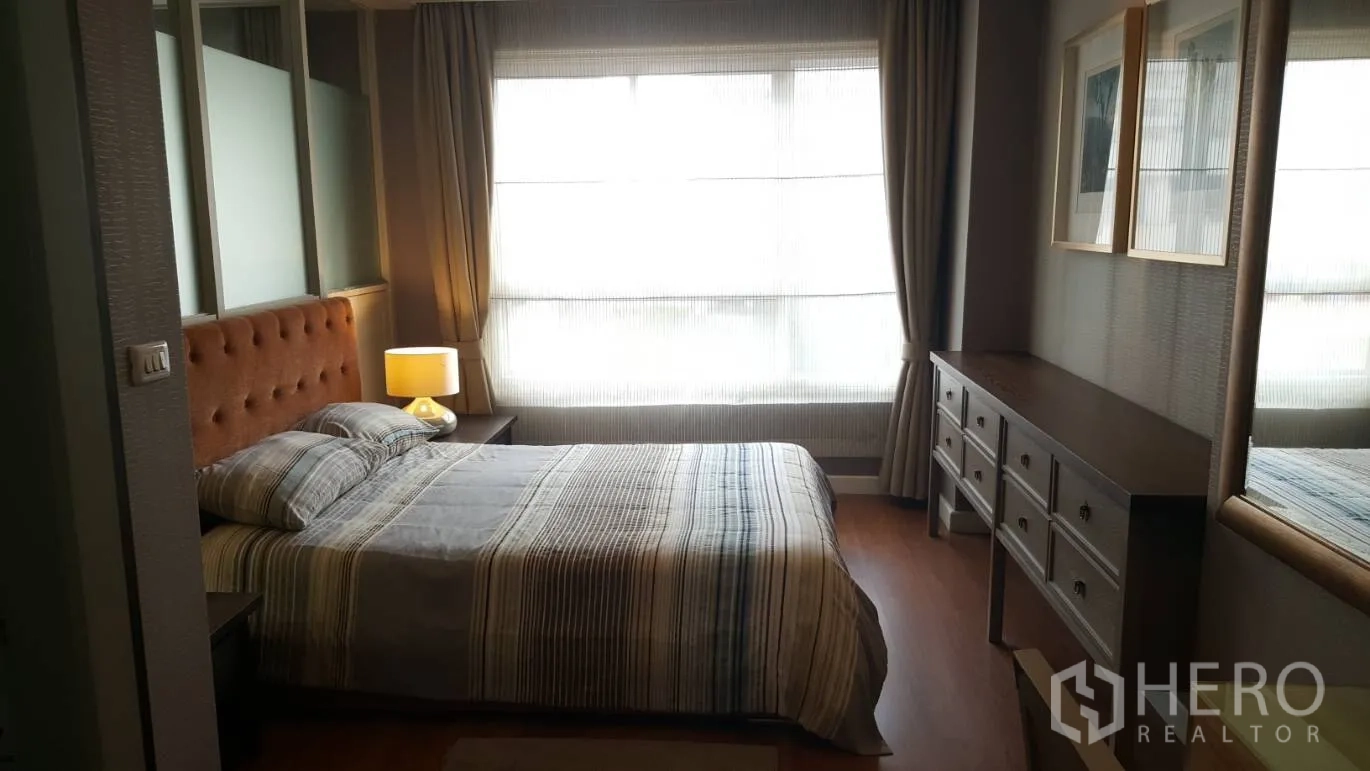 คอนโด ให้เช่าในKhlong Toei, Bangkok - ห้องนอนอบอุ่นพร้อมหัวเตียงบุผ้า โคมไฟข้างเตียง หน้าต่างกว้าง และตู้ลิ้นชักยาว