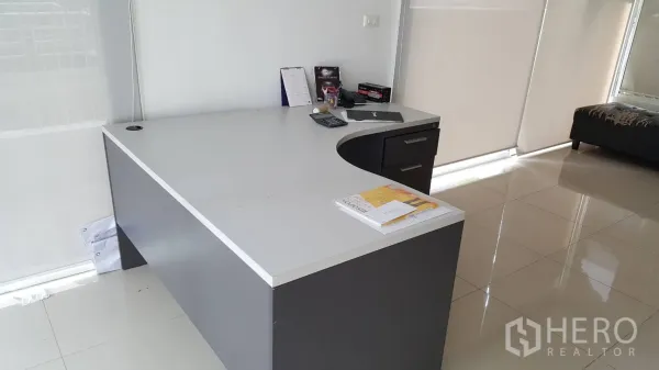 คอนโด ให้เช่าในPathum Wan, Bangkok - มุมทำงานเรียบร้อยพร้อมโต๊ะรูปตัวแอล เครื่องคิดเลข และมู่ลี่ม้วนริมหน้าต่าง