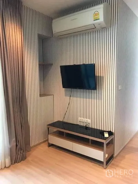 คอนโด ให้เช่าหรือขายในPhaya Thai, Bangkok - มุมทีวีติดผนัง ผนังลายทาง เครื่องปรับอากาศ และชั้นวางทีวี
