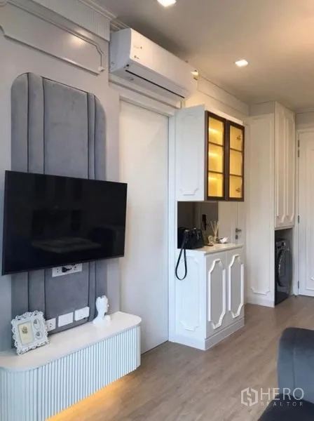 คอนโด ให้เช่าในWatthana, Bangkok - ผนังทีวีพร้อมแอร์และตู้โชว์ไฟสว่างในห้องรับแขก