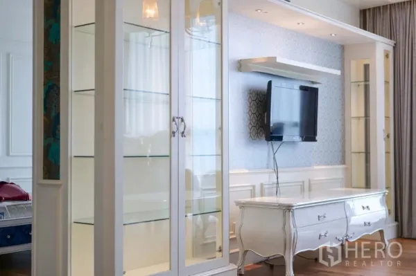 คอนโด ให้เช่าในKhlong Toei, Bangkok - ผนังห้องนั่งเล่นพร้อมตู้โชว์บิวท์อินสีขาว ทีวีติดผนัง และตู้คอนโซลสไตล์คลาสสิก