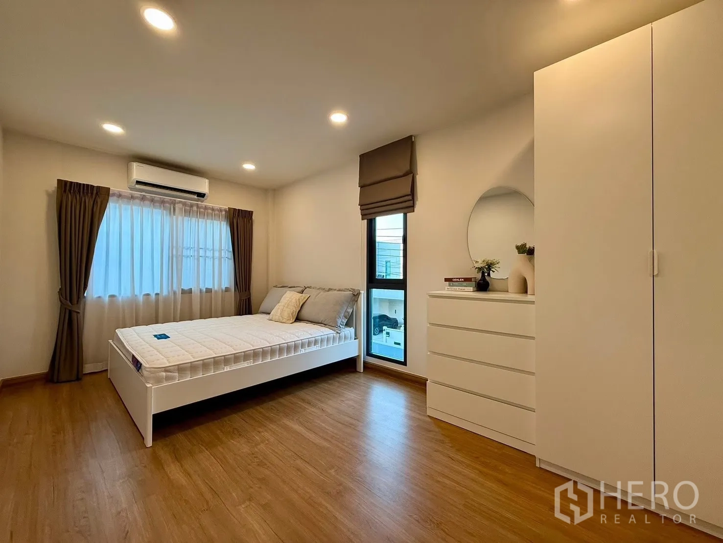 Detached House for rent in Bang Phli, Samut Prakan - Spacious bedroom with bed, wardrobe and dresser under warm lighting.