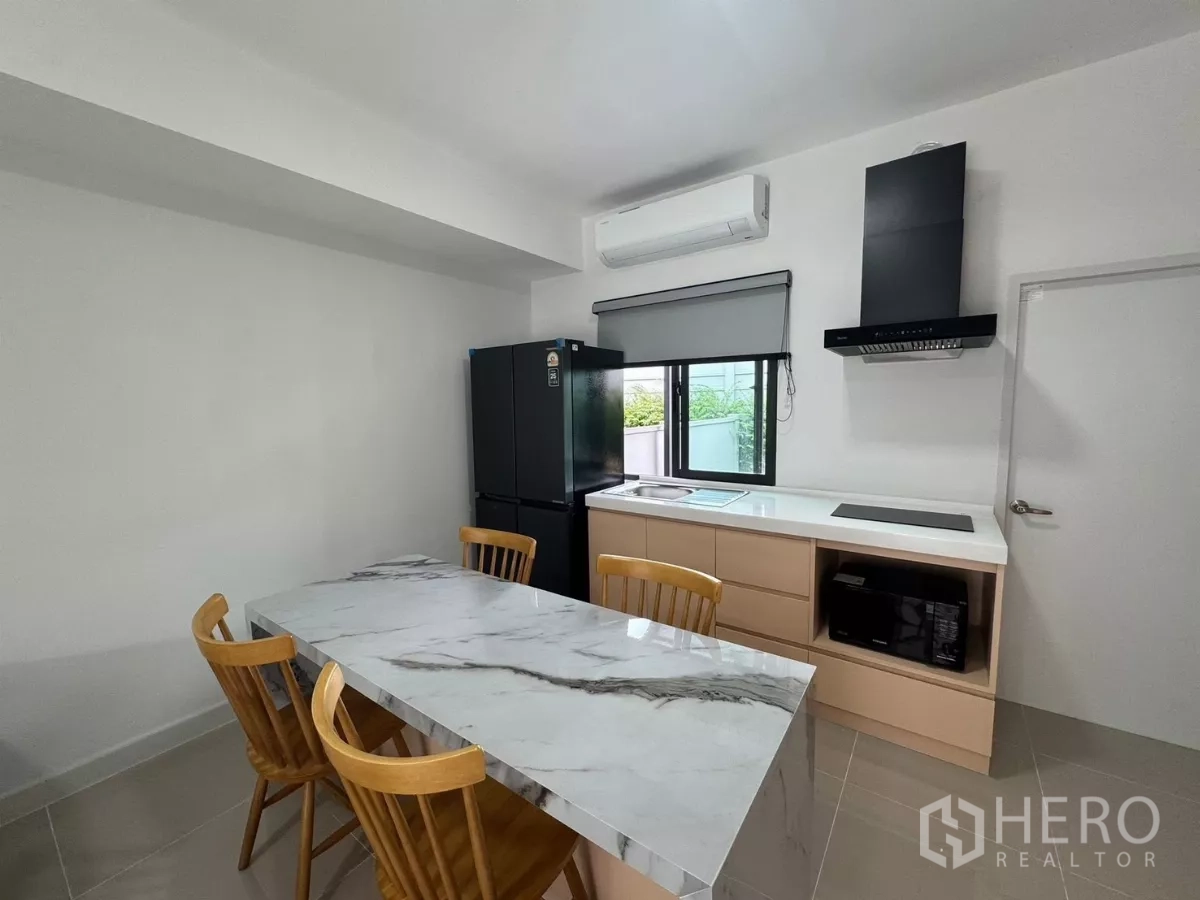 Townhouse for rent in Bang Phli, Samut Prakan - Compact kitchen featuring marble table, hob, hood, and window lighting
