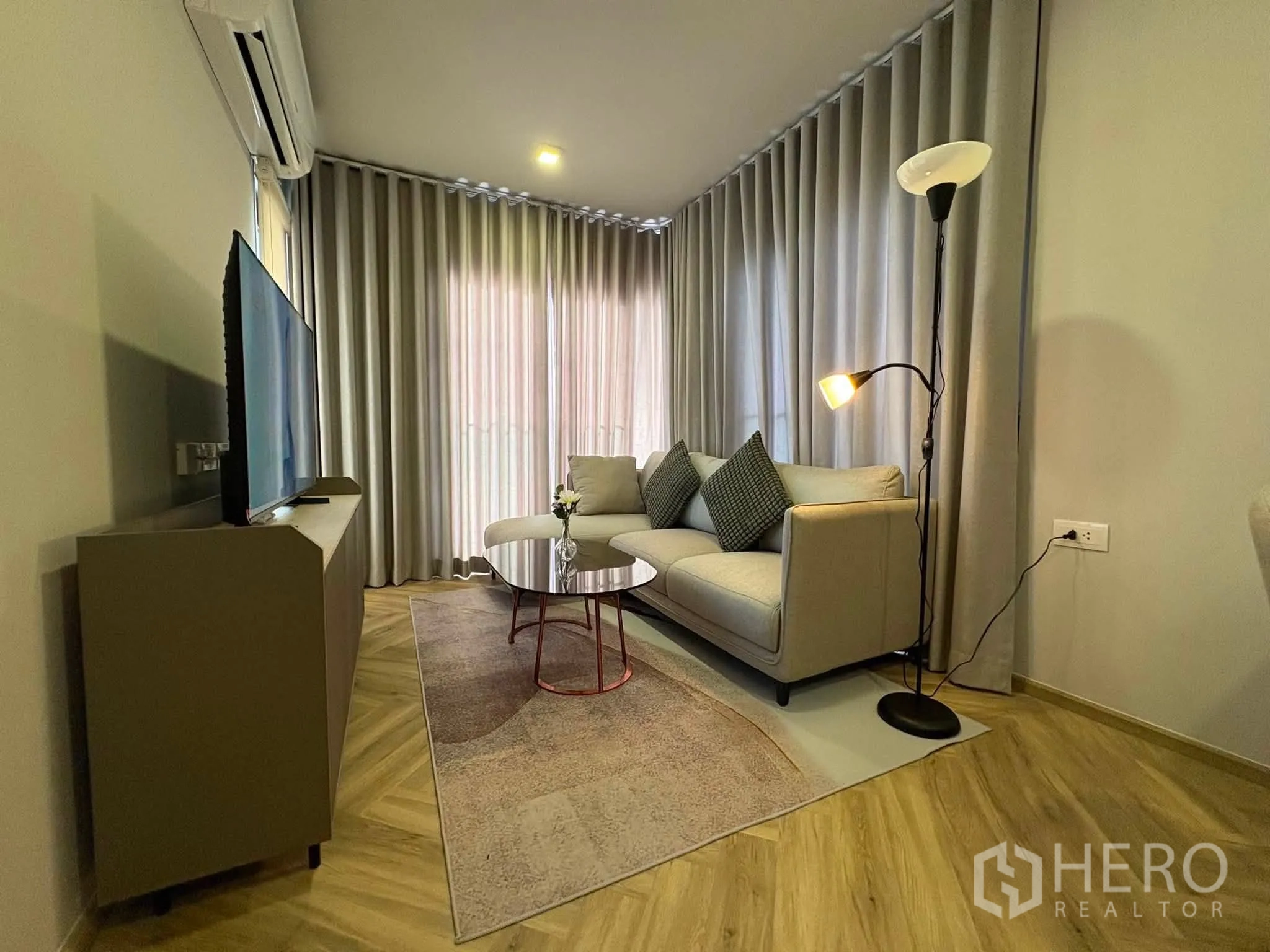 คอนโด for rent in Watthana, Bangkok - ห้องนั่งเล่นพร้อมโซฟา โคมไฟ ทีวี และผ้าม่านสูงจรดเพดาน