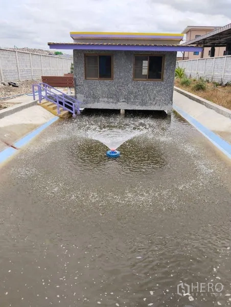 Warehouse for sale in Sai Noi, Nonthaburi - Aerated water pond with a small utility building on stilts.