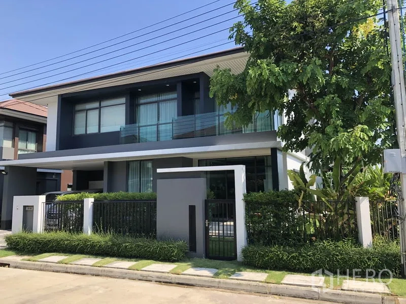 Detached House for rent in Bang Kapi, Bangkok - Modern two-storey detached house exterior with gated entrance, balcony and landscaped garden.