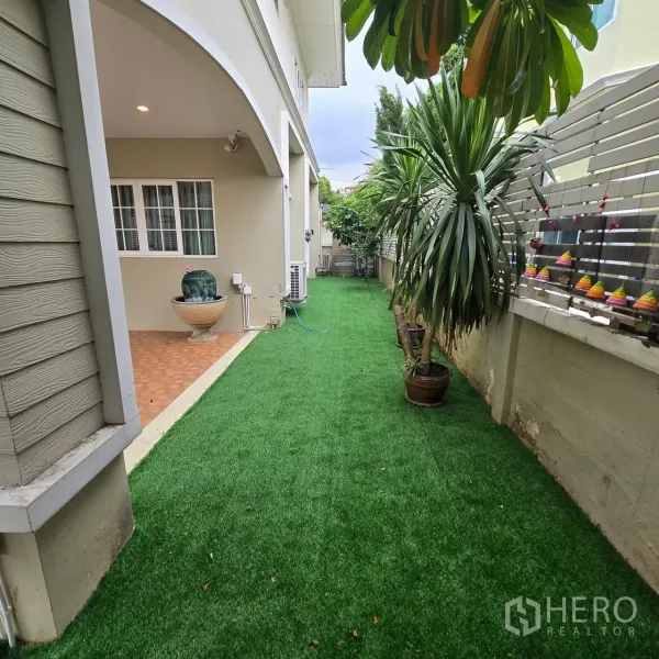 บ้าน ให้เช่าในMueang Pathum Thani, Pathum Thani - สวนข้างบ้านปูหญ้าเทียมและกระถางไม้เมืองร้อน