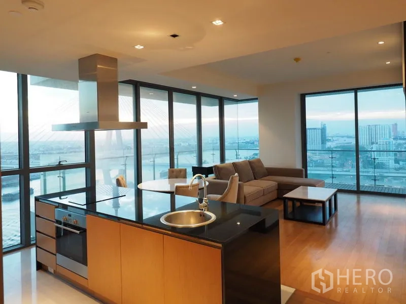 Condominium for rent in Yan Nawa, Bangkok - Open kitchen and living space with island counter and sweeping river and bridge views.