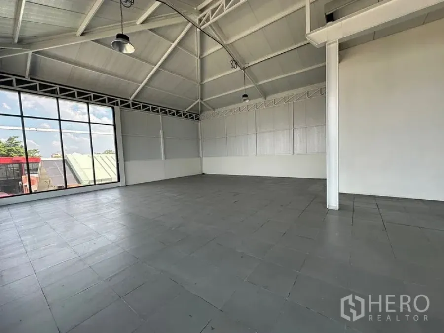 零售空间 出租在Bang Na, Bangkok - 宽敞室内，大片窗墙、山形屋顶与工业吊灯，墙面简洁素雅。