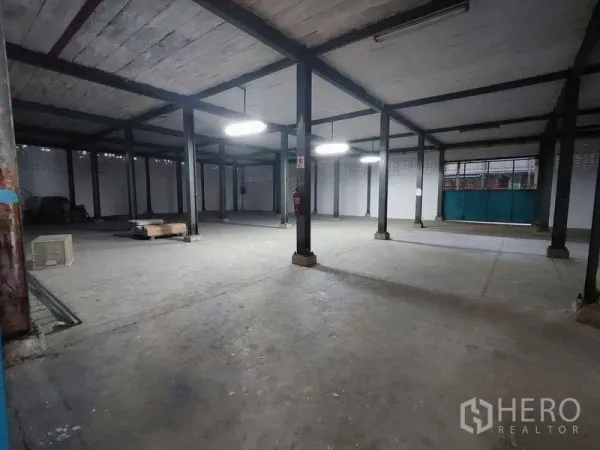 货栈 出租在Samut Sakhon - 仓库内部开阔，钢柱结构与荧光灯照明，适合存储或轻加工。