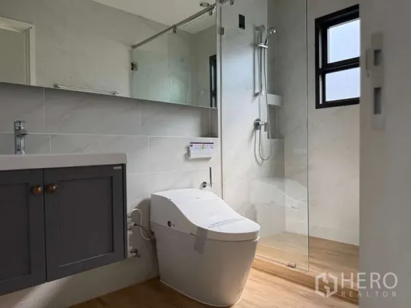 Detached House for rent or sale in Bang Phli, Samut Prakan - Modern bathroom with glass-enclosed shower, smart bidet toilet and vanity cabinet.