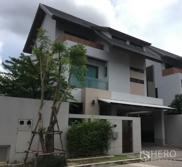 Detached House for rent or sale in Bang Kapi, Bangkok - Front elevation of three-storey detached house with carport and garden.
