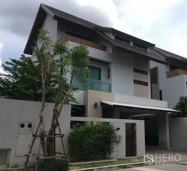 Detached House for rent or sale in Bang Kapi, Bangkok - Front elevation of three-storey detached house with carport and garden.