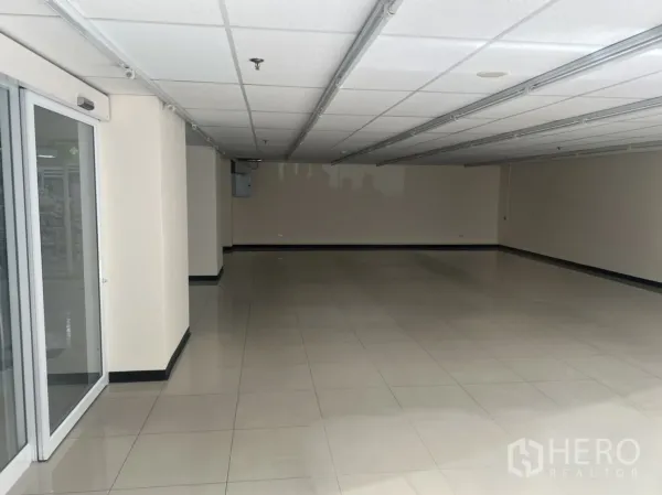 พื้นที่ขายปลีก ให้เช่าในWatthana, Bangkok - ประตูทางเข้ากระจกบานเลื่อน เปิดสู่พื้นที่ค้าปลีกขนาดใหญ่ ผนังโทนกลาง.