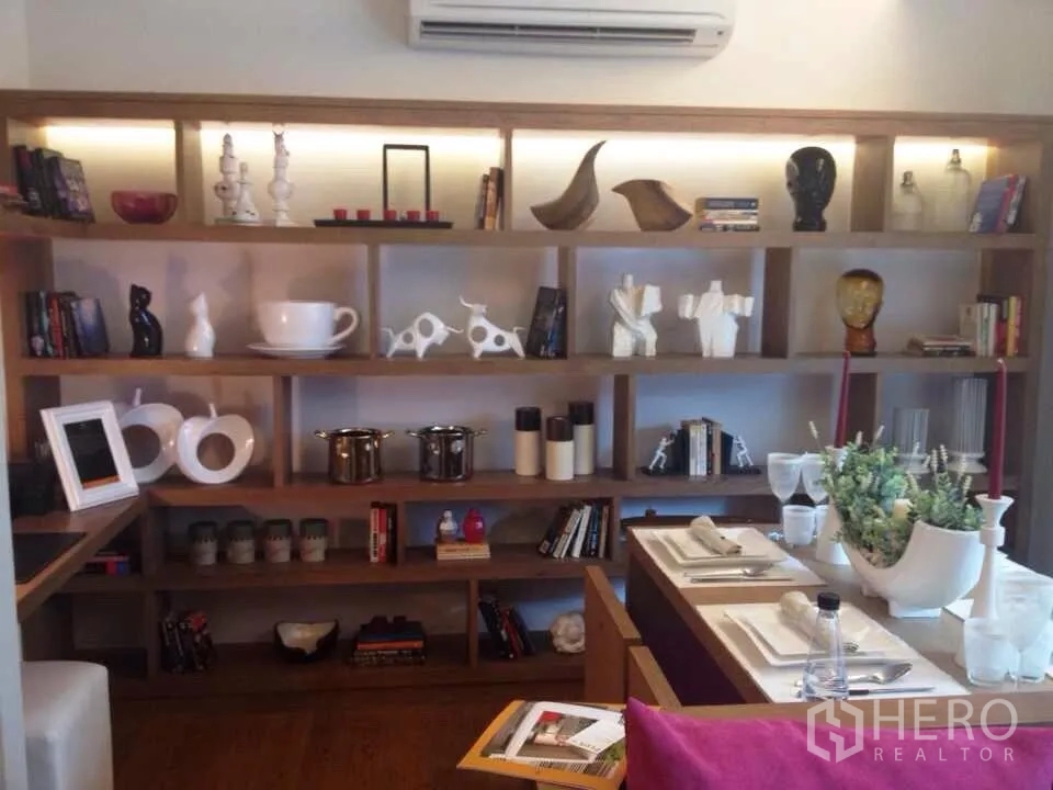 คอนโด ให้เช่าในWatthana, Bangkok - ภาพรวมโซนรับประทานอาหารและชั้นวางของเต็มผนังพร้อมไฟส่องและเครื่องปรับอากาศด้านบน