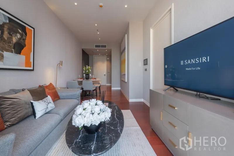 คอนโด ขายในWatthana, Bangkok - โซนนั่งเล่นเปิดโล่งเชื่อมโต๊ะรับประทานอาหาร โต๊ะกลางหินสีดำ และทีวี ในคอนโดทองหล่อ