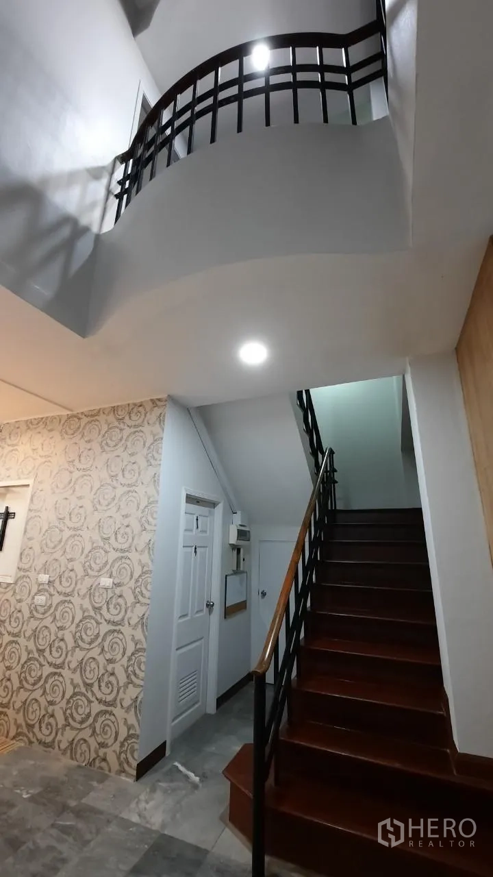Townhouse for sale in Suan Luang, Bangkok - Double-height stairwell with modern metal balustrade