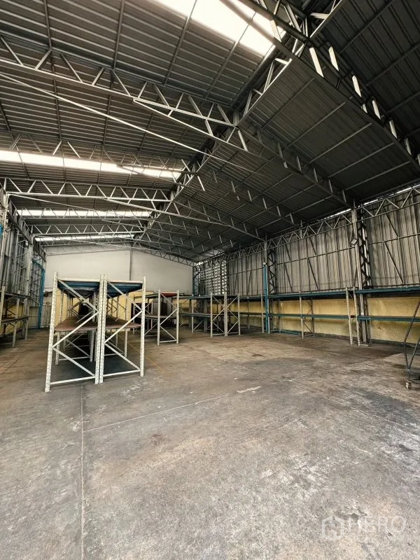 Warehouse for rent in Din Daeng, Bangkok - Spacious warehouse floor with steel roof structure and racking systems ready for use.