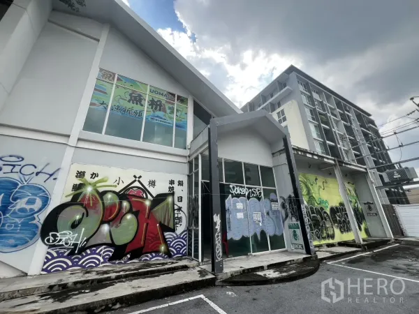 พื้นที่ขายปลีก ให้เช่าในWatthana, Bangkok - มุมมองด้านหน้ากระจกพร้อมกราฟฟิตีและคอนโดข้างเคียง