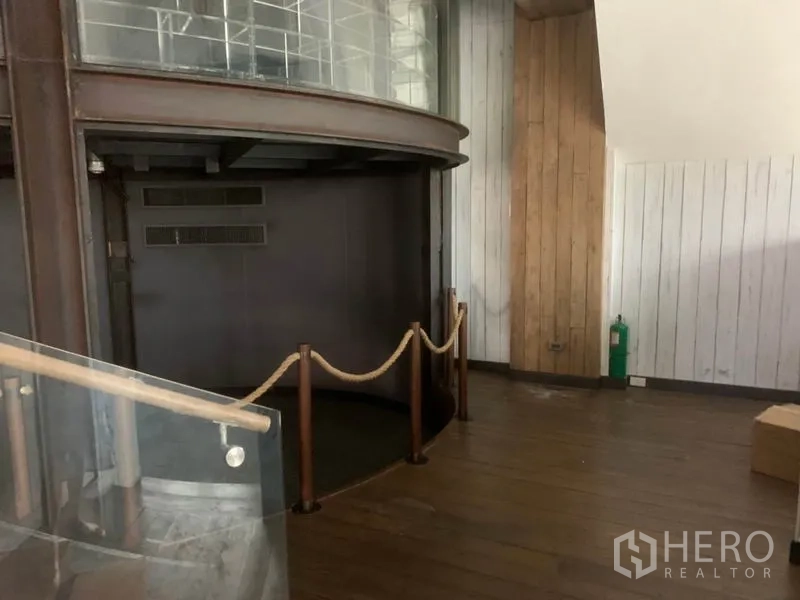 พื้นที่ขายปลีก ให้เช่าในWatthana, Bangkok - โซนชั้นล่างพื้นไม้ ผนังโค้ง ราวเชือกกั้น และราวกันตกกระจก