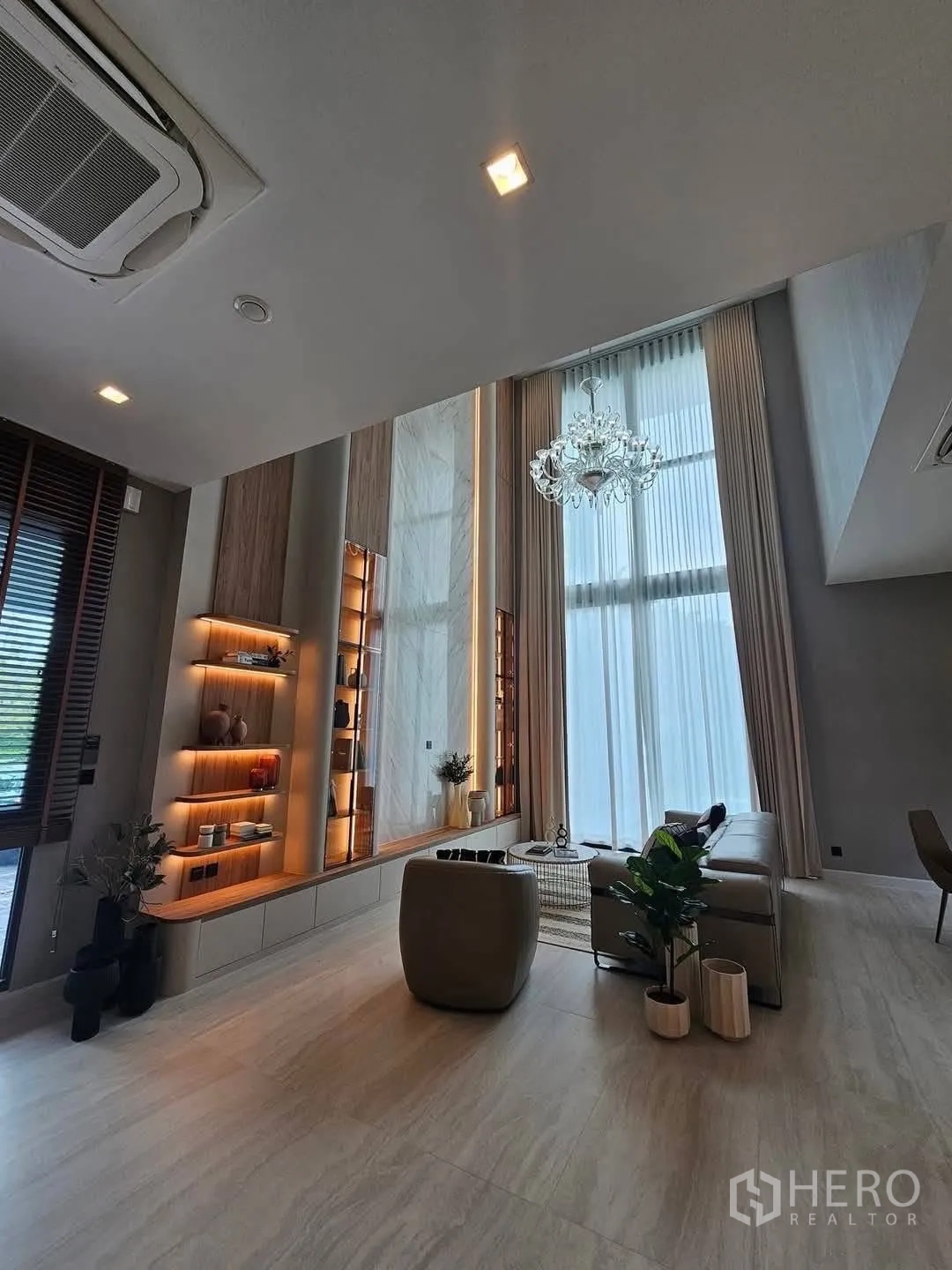 Detached House for rent or sale in Suan Luang, Bangkok - Double-height living room with chandelier, sofa set and tall curtains.