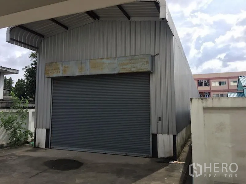 Home Office for rent or sale in Wang Thonglang, Bangkok - Standalone warehouse with corrugated metal exterior and roll-up shutter door.