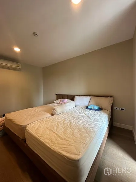 คอนโด ให้เช่าในKhlong Toei, Bangkok - ห้องนอนที่สองพร้อมเตียงคู่ พื้นไม้ และเครื่องปรับอากาศติดผนัง