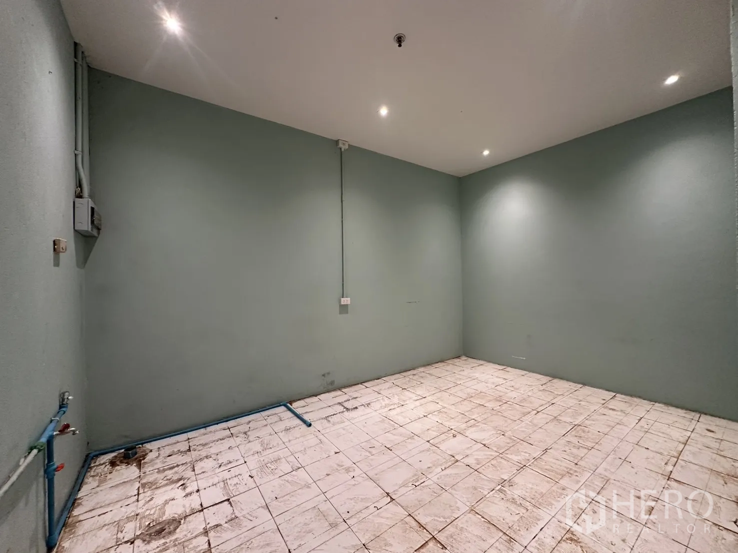 พื้นที่ขายของ for rent in Watthana, Bangkok - โซนบริการผนังสีเขียว พื้นกระเบื้องสีขาว มีท่อน้ำสีน้ำเงินและตู้ไฟ