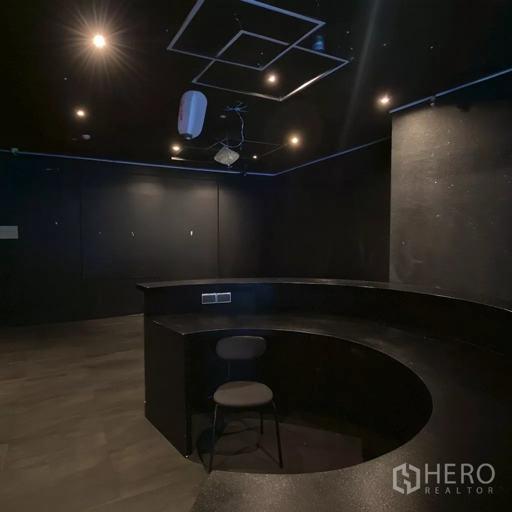 零售空间 出租 - 封闭房间，内置半圆形吧台与射灯，适合作为后勤或吧台区。
