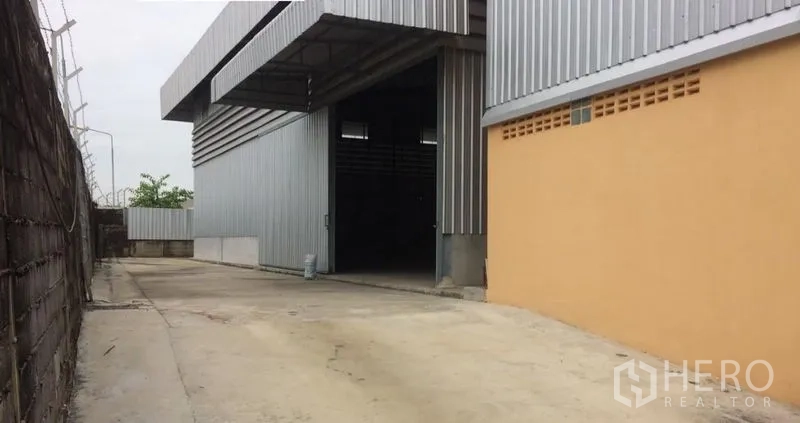 Warehouse for rent in Phra Samut Chedi, Samut Prakan - Covered loading bay and large roller-door style entrance at the warehouse exterior.