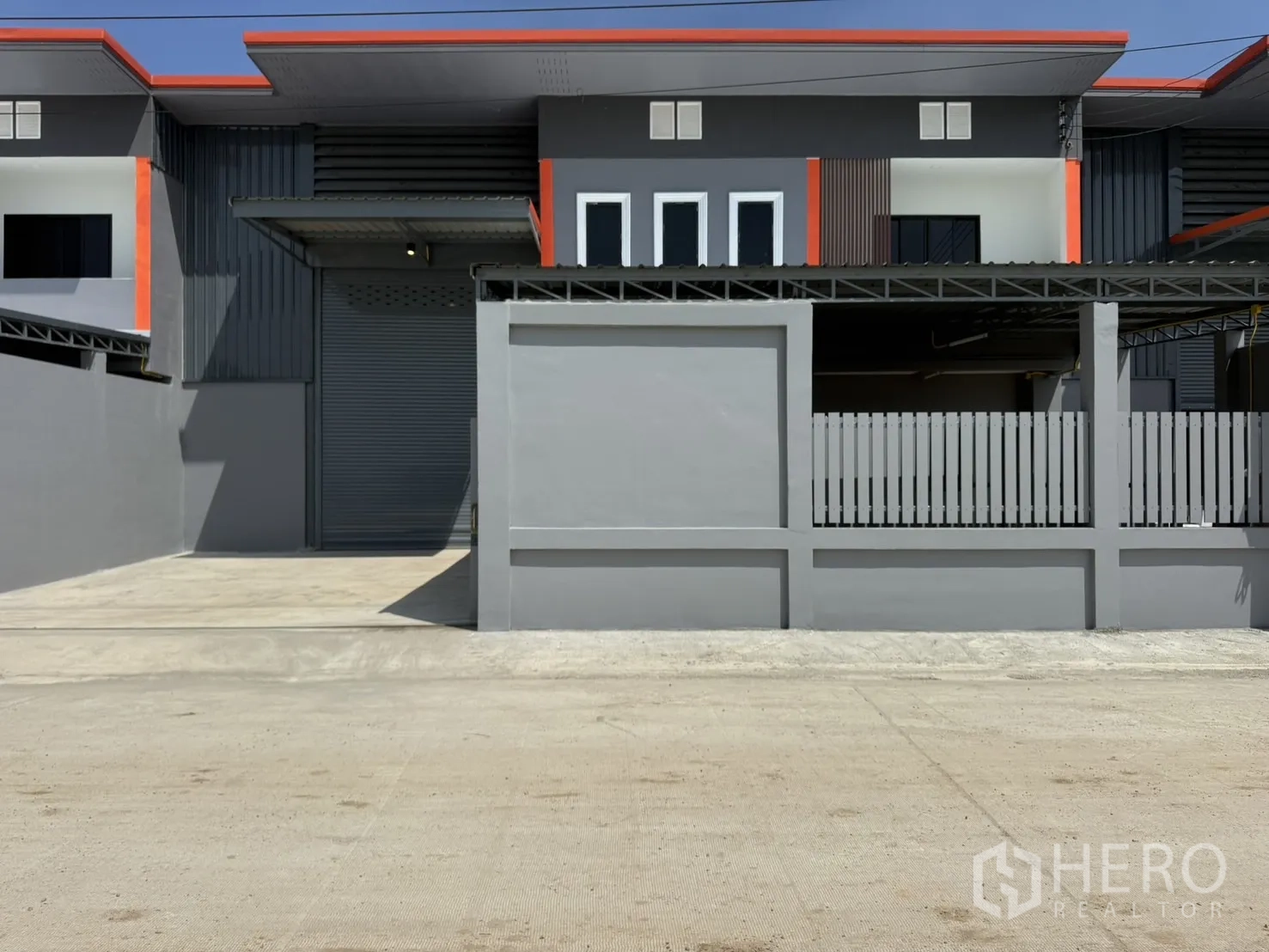 โกดัง for rent in Lam Luk Ka, Pathum Thani - ด้านหน้าอาคารพร้อมประตูม้วนและลานรั้วหน้าบ้าน