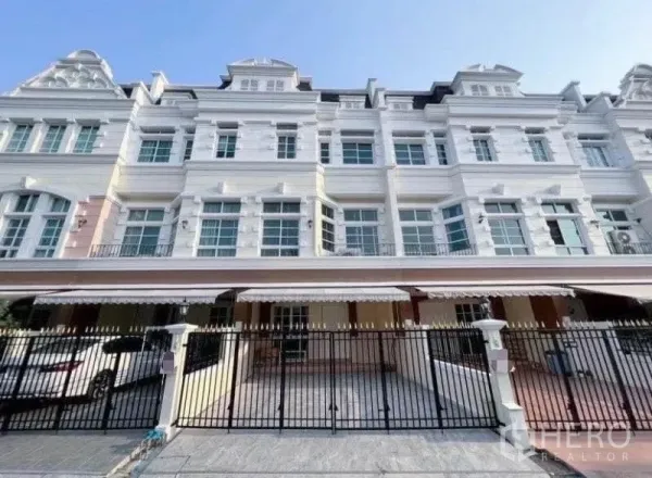 Townhouse for rent in Phra Khanong, Bangkok - European‑style multi‑storey townhouse facade with balconies, gated carport and driveway.