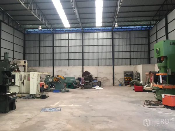 Warehouse for rent in Lat Krabang, Bangkok - Open warehouse interior with high steel roof, skylights, and concrete floor for machinery.