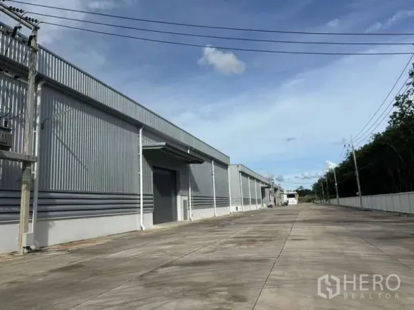 货栈 出租在Nikhom Phatthana, Rayong - 沿金属外墙仓库的长服务道路，配有电力线路