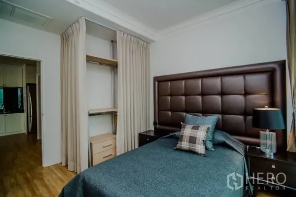 Condominium for rent or sale in Watthana, Bangkok - Cozy second bedroom with padded headboard, open built-in closet, and bedside lamps.