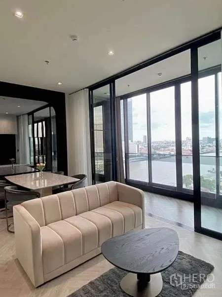 公寓 出租 - 明亮客厅，沙发、茶几与餐桌，整面玻璃尽享河景。