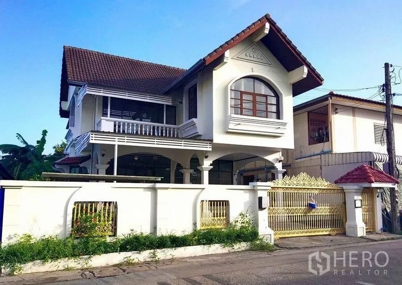 Detached House for rent in Khlong Toei, Bangkok - Front exterior view showing the detached house, tiled roof, white wall and gated entrance.